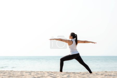 Lifestyle athletic woman yoga exercise and pose for healthy life. Young girl or people pose balance body vital zen and meditation workout and fitness sport outdoor on sand beach