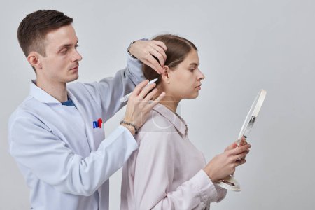 Photo for Otoplasty markup for surgical reshaping of the pinna, or outer ear for correcting an irregularity and improving appearance. Surgeon doctor marking girl ear before otoplasty cosmetic surgery - Royalty Free Image