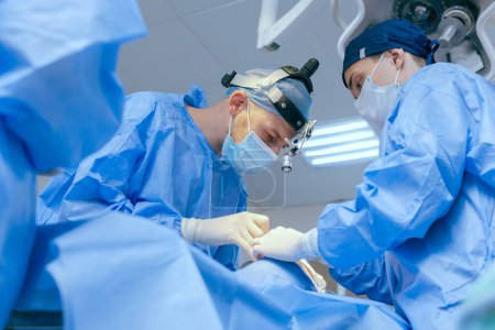Téléchargez les photos : Chirurgiens masculins effectuer une chirurgie dans la salle d'opération, chirurgien plastique dans la salle d'opération - en image libre de droit