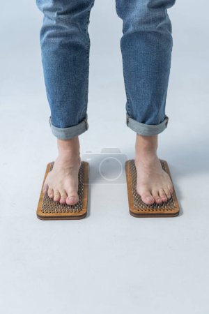 Sadhu board, yoga board with nails, guy stands on the board with nails, yoga concept