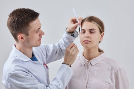 Photo for Blepharoplasty of a woman marking on her face before plastic surgery to change the eye area in a medical clinic - Royalty Free Image