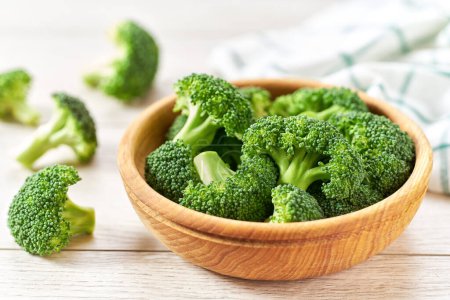 Photo for Fresh organic broccoli in a bowl on a white wooden table. - Royalty Free Image