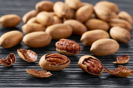 Photo for Organic pecan nuts on a black kitchen table, selective focus. - Royalty Free Image