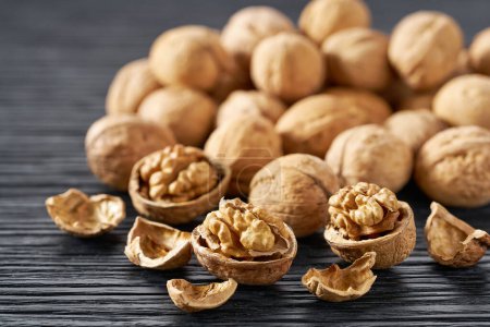 Photo for Organic walnuts nuts on a black kitchen table, selective focus. - Royalty Free Image