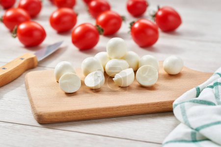Foto de Bolas de queso mozzarella bebé con tomates cherry en una mesa de cocina. bolas de queso mozzarella italiana tradicional. - Imagen libre de derechos