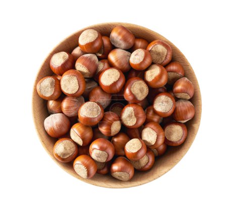 Foto de Unpeeled hazelnuts in a wooden bowl isolated on white.Front view. - Imagen libre de derechos