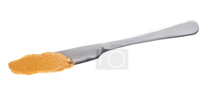 Photo for Peanut butter on a metal knife isolated on white background, top view. Knife with creamy peanut butter isolated on white background. - Royalty Free Image
