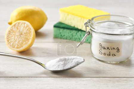 Photo for Non-toxic cleaner, baking soda and lemon on a white kitchen table. - Royalty Free Image