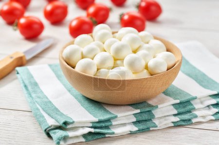 Foto de Mini mozzarella cheese balls with cherry tomatoe on a white kitchen table. - Imagen libre de derechos