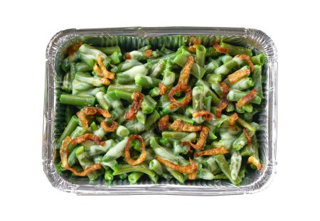 Photo for Green bean casserole with crispy fried shallots onion in a disposable square aluminium foil baking dish isolated. Foil food box with takeaway meal. - Royalty Free Image