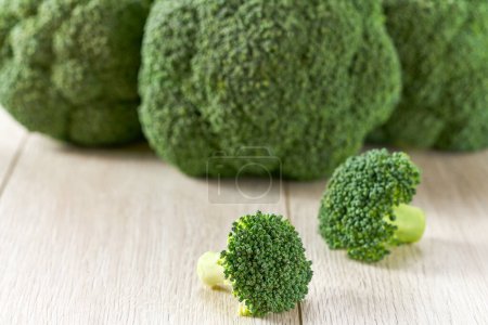 Foto de Brócoli orgánico verde crudo en una mesa blanca, enfoque selectivo. - Imagen libre de derechos