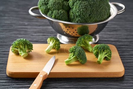 Photo for Fresh raw broccoli on a cutting board, healthy food preparation. - Royalty Free Image