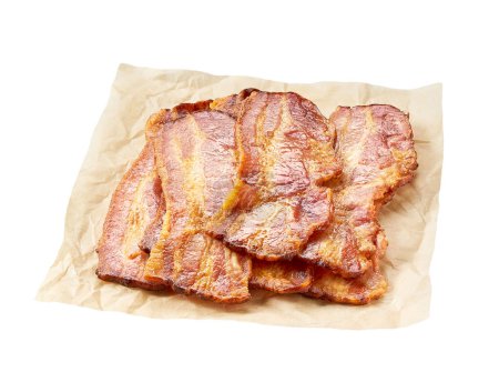 Téléchargez les photos : Rashers au bacon cuits sur un parchemin isolé sur fond blanc. lanières de bacon frites sur un papier sulfurisé isolé sur fond blanc. - en image libre de droit
