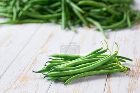 Photo for Organic green beans on a white wooden table, copy space for text. - Royalty Free Image
