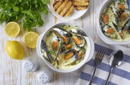 Téléchargez les photos : Délicieuse soupe méditerranéenne de fruits de mer aux moules et herbes sur une table blanche, vue sur le dessus. - en image libre de droit