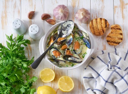 Téléchargez les photos : Délicieuse soupe méditerranéenne de fruits de mer aux moules et herbes sur une table blanche, vue sur le dessus. - en image libre de droit