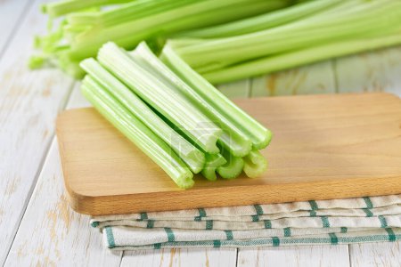 Photo for Fresh green celery stalks on a white wooden table. - Royalty Free Image