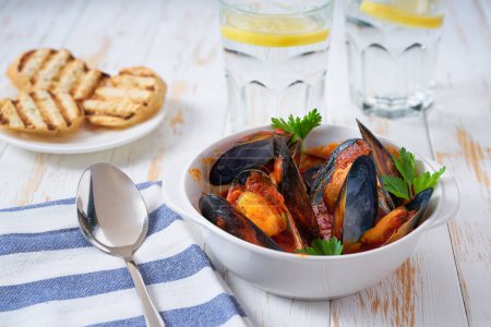 Photo for Tomato soup with mussels on a white table, selective focus. - Royalty Free Image