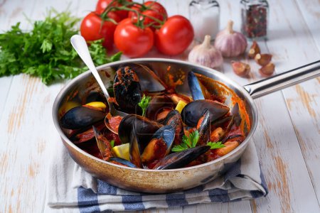 Téléchargez les photos : Moules cuites maison avec sauce tomate, ail, herbes italiennes, dans une casserole, vue sur le dessus. - en image libre de droit