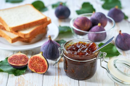Photo for Plate with slices of bread and delicious figs jam on wooden table. Bread and figs homemade jam on wooden table. - Royalty Free Image