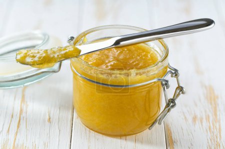 Photo for Jar of tasty lemon jam on a white wooden table. - Royalty Free Image