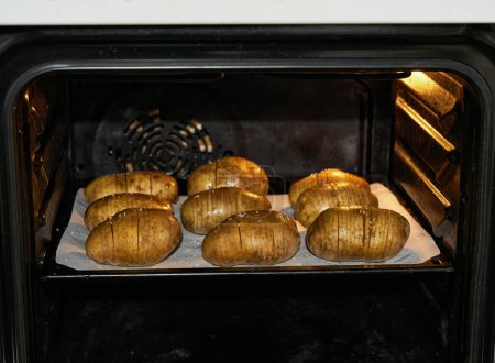 Photo for Homemade hasselback potato in the oven, selective focus. - Royalty Free Image