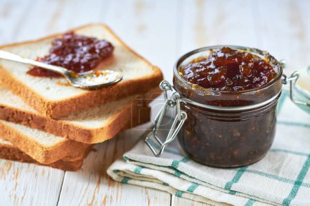 Photo for Bread and homemade figs jam on a white wooden table. - Royalty Free Image