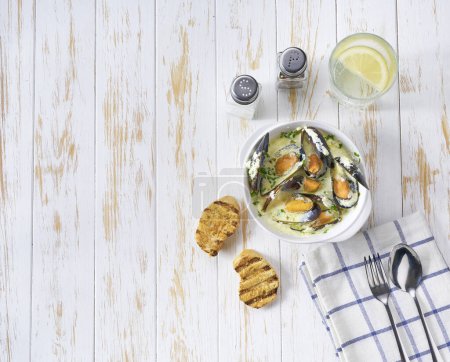 Téléchargez les photos : Délicieuse soupe méditerranéenne de fruits de mer aux moules et crevettes sur une table blanche, vue sur le dessus. - en image libre de droit