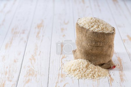 Photo for Organic basmati rice in sack bag.Sack with organic white basmati rice . Organic white basmati rice in burlap bag and heap of  rice. - Royalty Free Image