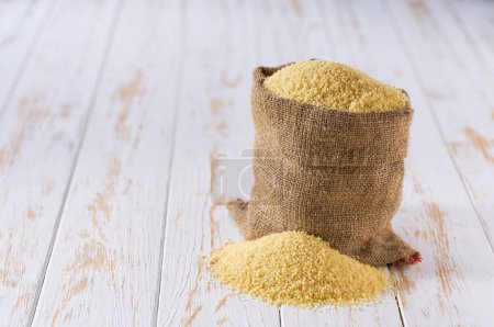 Téléchargez les photos : Couscous bio en sac. Sac avec couscous bio. Couscous sec en sac de toile de jute et tas de couscous. - en image libre de droit