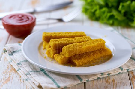 Photo for Fish fingers sticks with parsley and ketchup on a wooden table. - Royalty Free Image