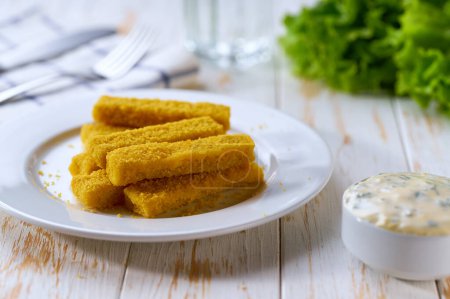 Photo for Crispy golden fried fish fingers sticks with lemon and tartar sauce on wooden table. - Royalty Free Image