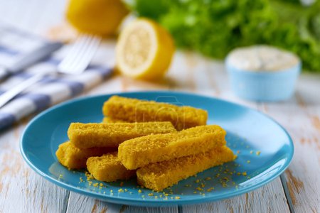 Photo for Crispy golden fried fish fingers sticks with lemon and tartar sauce on wooden table. - Royalty Free Image