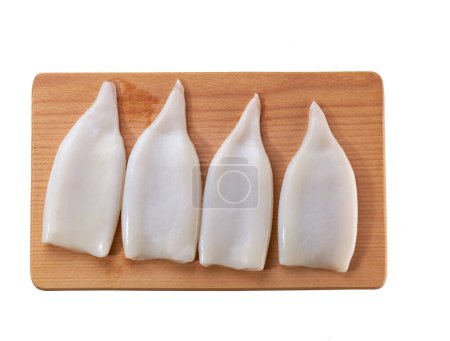 Foto de Filete fresco de calamar o sepia en tabla de cortar aislado sobre un fondo blanco. Piso Lay, vista superior. - Imagen libre de derechos