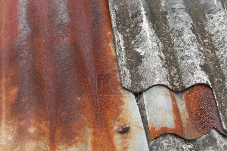 A rusted corrugated tin roof piled up with old corrugated asbestos. Can be used as an illustration for presentations.