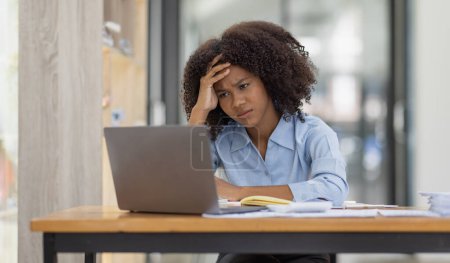 Téléchargez les photos : Afro-américaine famille stressée tout en travaillant sur ordinateur portable, Fatigué femme triste avec maux de tête se sentir malade au bureau copie espace. - en image libre de droit