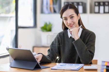 Téléchargez les photos : Joyeux asiatique femme d'affaires travaillent dans le bureau de l'espace de travail. faire de la finance mathématique sur bureau en bois au bureau, fiscalité, comptabilité, concept financier. - en image libre de droit