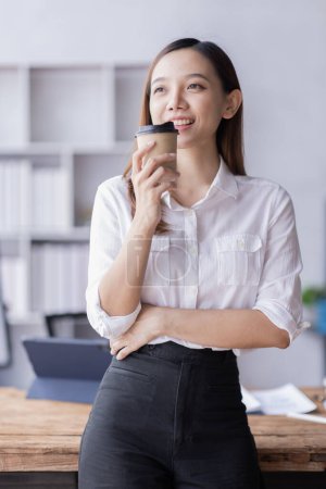 Photo for Portrait of asian Young beautiful lady drinking coffe and look to the working on laptop computer sitting in coffee shop, business report Financial and Accounting concept. - Royalty Free Image