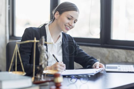 Téléchargez les photos : Statue of Justice and female lawyer in suit at workplace with laptop, gavel and femida in office. Law, legal services, advice, Justice and real estate concept. - en image libre de droit