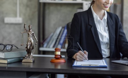 Téléchargez les photos : Statue of Justice and female lawyer in suit at workplace with laptop, gavel and femida in office. Law, legal services, advice, Justice and real estate concept. - en image libre de droit