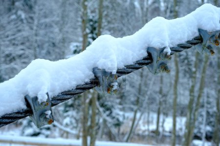 Photo for The cable ties of the pedestrian bridge are screwed together with screws. snowy winter. - Royalty Free Image