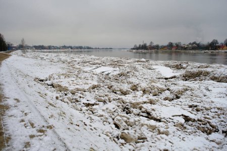 Téléchargez les photos : Jekabpils after the flood. River Daugava with ice piles on the banks. A dark, dreary January day. - en image libre de droit