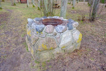Photo for Idyllic outdoor barbecue area - built with flat stones campfire place. For public use. - Royalty Free Image