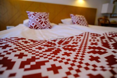 Téléchargez les photos : Aire de loisirs dans l'hôtel. Linge de lit avec symboles nationaux rouges de l'Estonie - en image libre de droit