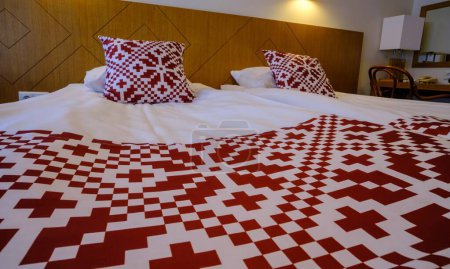 Téléchargez les photos : Aire de loisirs dans l'hôtel. Linge de lit avec symboles nationaux rouges de l'Estonie - en image libre de droit