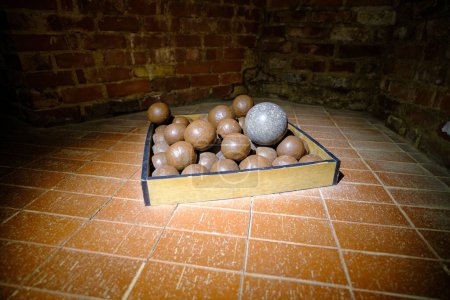 Photo for The balls of ancient medieval cannons are piled in a pile in the basement of the castle. - Royalty Free Image