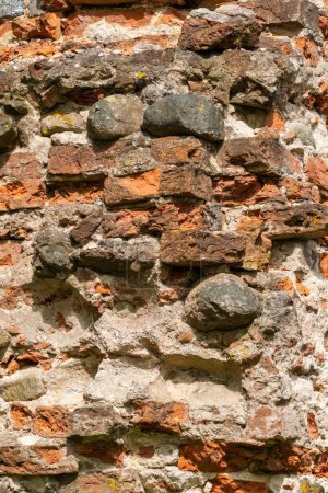 Detailed view of an old stone and brick wall, showcasing the textures and craftsmanship of ancient construction.