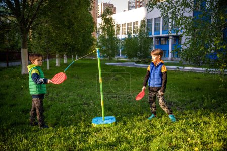 Deux amis jouent à la balle d'attache swing jeu de balle dans le camping d'été. Deux garçons frère heureux loisirs sain temps actif plein air concept.