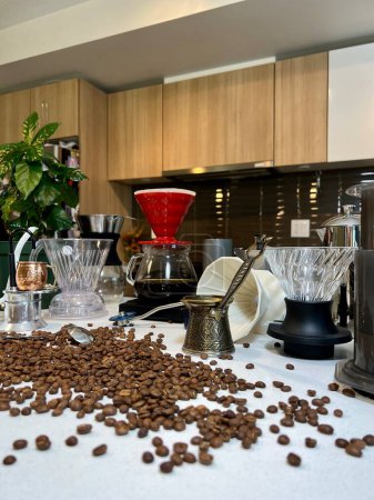 Téléchargez les photos : Différents équipements de café professionnels sur la table à côté de la fleur de café ainsi que différents accessoires pour brasser le café Craft ad Au premier plan les haricots sont dispersés sur la table - en image libre de droit