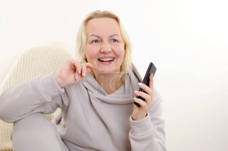 Téléchargez les photos : Souriante femme d'affaires d'âge moyen sourit parler sur smartphone profiter d'une conversation agréable avec le client, directrice des ventes rend fructueux concept de transaction rentable conversation agréable au téléphone - en image libre de droit